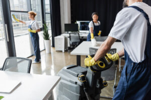 Professionelle Reinigungskraft bei der täglichen Unterhaltsreinigung eines modernen Büroarbeitsplatzes.